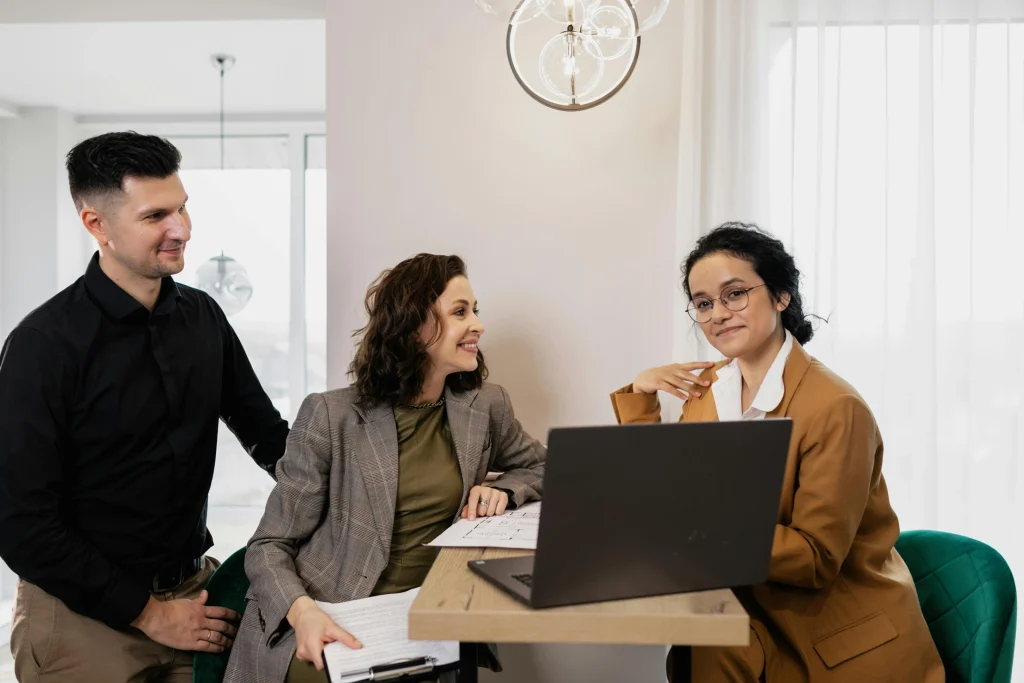 "Happy clients sharing positive feedback with a business representative in a modern office setting.
